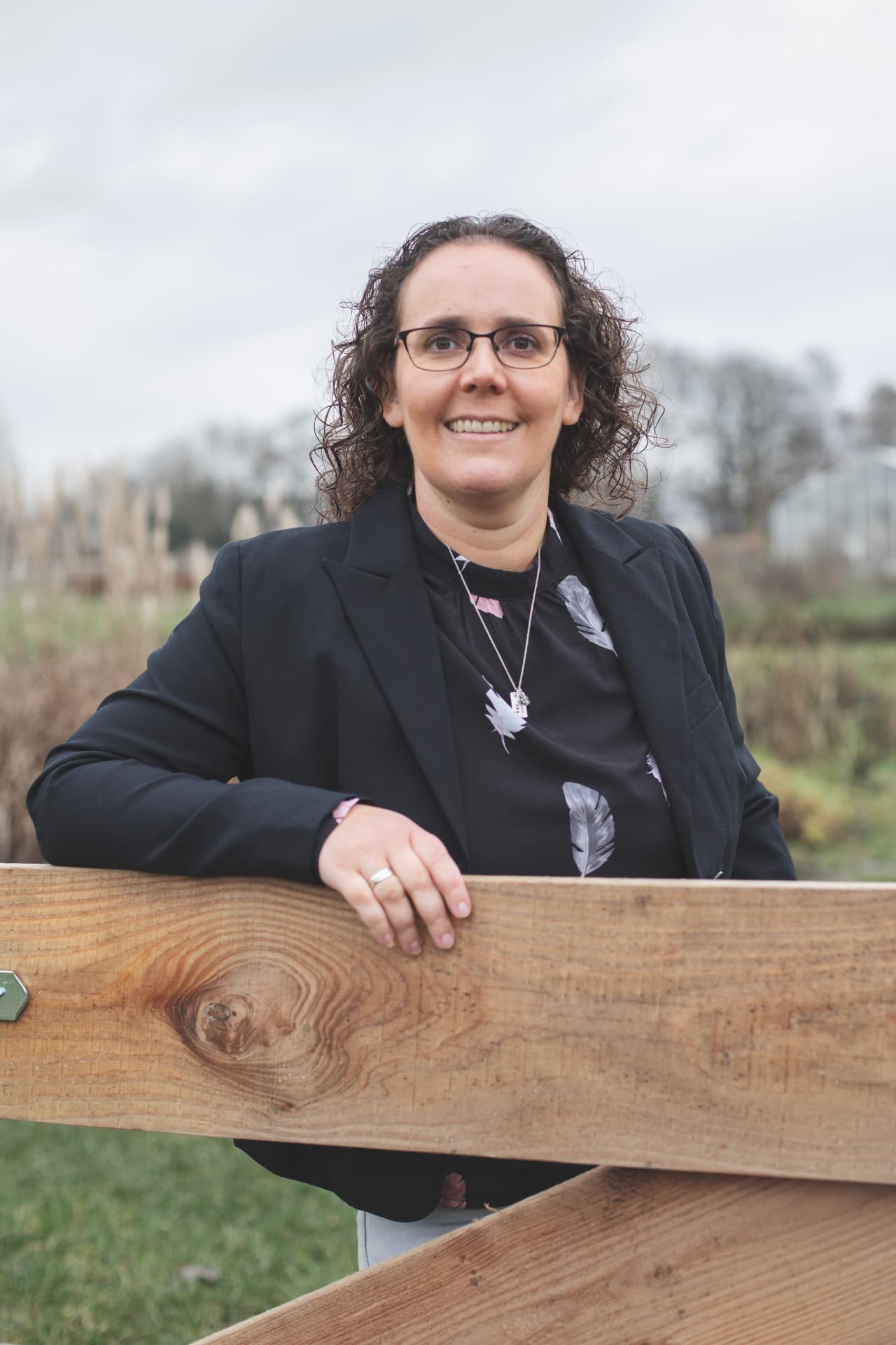 Femke Dirkx leunend op een houten hek